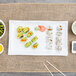 An American Metalcraft wavy stoneware platter with sushi, vegetables, and chopsticks on a table.