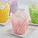 A close up of a yellow and white polka dot Enjay tulip baking cup.