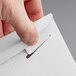 A finger opening a white Lavex Stayflats mailer box with a tab lock.