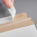 A person's hand opening a white Lavex Stayflats envelope with white adhesive.