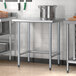 A Steelton stainless steel kitchen work table with metal legs.