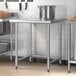 A Steelton stainless steel open base work table with metal legs.