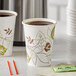 Two Dixie Pathways paper cups with lids and a tea bag on a counter.