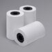 A group of Point Plus thermal paper rolls on a gray surface.