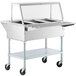A ServIt stainless steel electric steam table on wheels with a sneeze guard and tray slide.