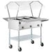 A ServIt stainless steel electric steam table with a clear sneeze guard over the food.