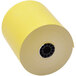 A roll of Point Plus yellow thermal paper with a black circular object on it.