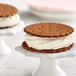 A close up of a cookie sandwich with white frosting on top.