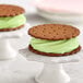 A close up of a cookie with green frosting on top.
