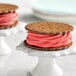 Two cookies with pink and red frosting on top.