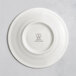 A white RAK Porcelain saucer with an embossed logo.
