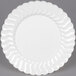 A close-up of a Fineline Flairware white plastic plate with wavy edges.