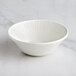 A RAK Porcelain ivory bowl with wavy lines on a white surface.