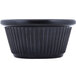 A close-up of a black fluted ramekin with a rippled edge.