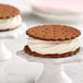 A cookie sandwich with Creamery Ave. Vanilla Soft Serve Mix between two cookies with white frosting.