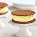 A vanilla ice cream sandwich with yellow frosting on a Lemon Blueberry Soft Serve cookie.