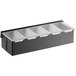 A matte black stainless steel condiment bar with five plastic containers.