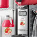 A Narvon strawberry slushy machine with a container of Narvon strawberry slush.