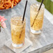 Two glasses of Pure Craft Beverages Ginger Beer with straws on a marble table.