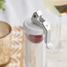 A white wine bottle with a cork stopper and a metal lever on top.