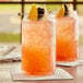 A table with two glasses of pink Pure Craft Blackberry Lemonade with orange and lemon slices.