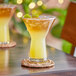 Two Libbey martini glasses filled with yellow liquid on a table