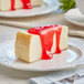A slice of cheesecake with Lucky Leaf Strawberry Glaze on a plate.