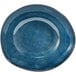 A blue porcelain bowl with a small rim on a table with a blue and white circle.