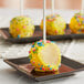 Individually wrapped yellow Chalet Desserts lemon cake pop with sprinkles.