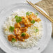 A plate of Gold Thai Jasmine Rice with chicken and spices on a white background.