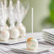 Individually wrapped Chalet Desserts carrot cake pops on a white plate.