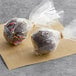 Individually wrapped chocolate cake pops on a counter.
