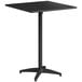 A Lancaster Table & Seating black powder-coated aluminum bar height table with a metal pole.