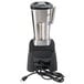A Waring commercial blender with a cord attached to it on a counter.