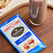 A glass of chocolate milk next to a package of Land O Lakes Hazelnut and Chocolate Cocoa mix.