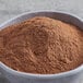 A bowl of brown Ground Ceylon Cinnamon powder on a table.