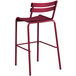 A red Lancaster Table & Seating outdoor barstool with a metal frame and backrest.