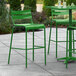 A green Lancaster Table & Seating outdoor barstool on a concrete patio.
