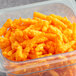 A plastic container of Good's Crunchy Cheese Curls on a table.