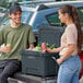 A man and woman standing next to a CaterGator outdoor cooler.