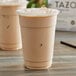 A close-up of a plastic cup of Tazo London Fog Latte concentrate with foam on top.