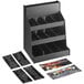 A ServSense black plastic countertop condiment organizer with 12 sections and header decals holding various items.