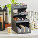 A black ServSense countertop condiment organizer with 15 sections and a bottom drawer.