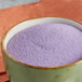 A bowl of purple Great Western Grape Popcorn Glaze powder on a table.