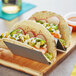 A rectangular stainless steel taco holder with two tacos.