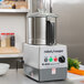 A Robot Coupe commercial food processor with a bowl of vegetables.