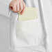 A person holding a note in the pocket of a white Malt Impact ProMax lab coat.