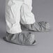 A person wearing white Malt ProMax coveralls with attached boots.