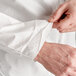 A person's hand pulling a white Malt ProMax coverall out of the sleeve.