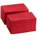 A stack of red Choice 2-Ply Dinner Napkins on a table.